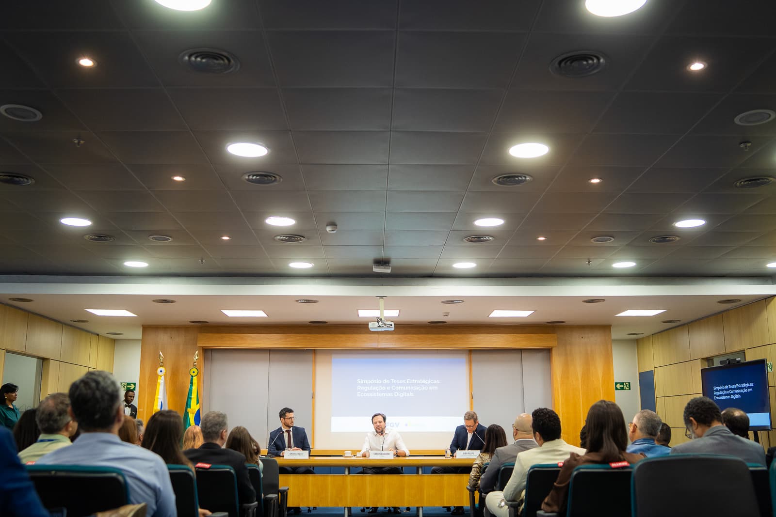Visão geral do auditório com o público acompanhando a mesa do Simpósio de Teses Estratégicas da FGV e da ANATEL