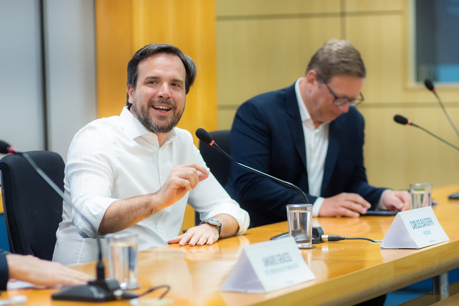 Presidente da ANATEL sorrindo durante a conversa na mesa